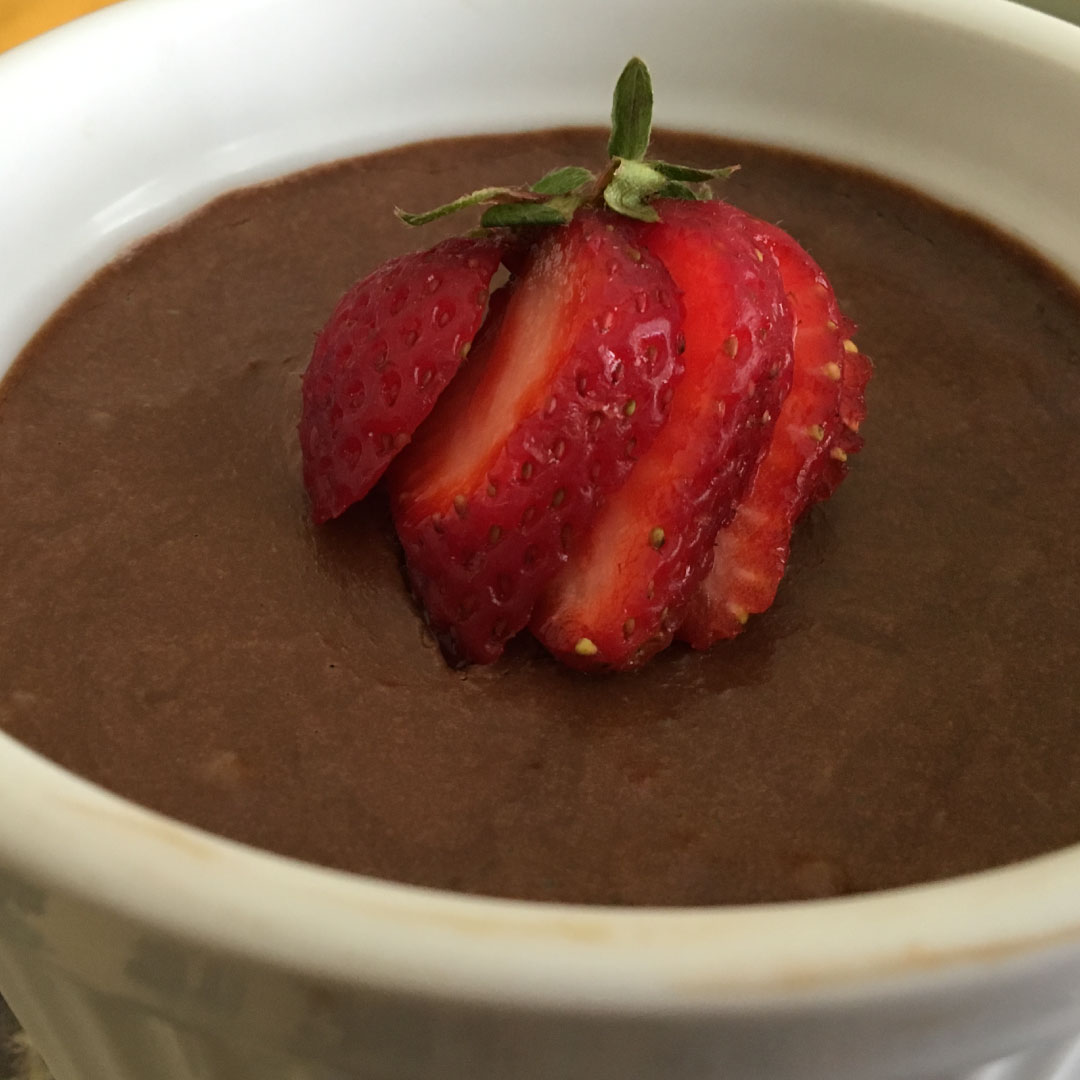sliced strawberry on chocolate mousse in a white cup